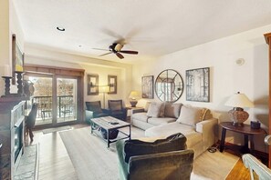 A living room with a sofa, coffee table, and a ceiling fan. - Beautiful condo in the heart of town with hot tubs & pool - walk to lifts (Breckenridge)