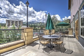 Ein Balkon mit Gartenmöbeln, Blick auf Berge und ein Gebäude im Hintergrund.