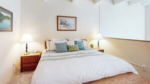 A bedroom with a large bed, two bedside tables with lamps, a framed picture on the wall, and a window. - Third-Floor Condo + Loft w/Mtn Views, Balcony, Wood Fireplace, & Shared Hot Tub (Copper Mountain)