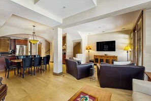 A spacious living area with a dining table, sofas, and a TV. - Cozy townhome with fully stocked kitchen, fast wifi & easy ski access (Copper Mountain)