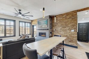 Eine moderne Küche mit Kamin, Essbereich und einer Sitzecke mit Sofa und Stühlen.