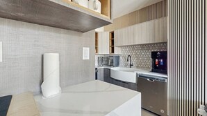 A modern kitchen with a built-in dishwasher, a coffee machine, and a large white countertop. - Charming, walk-to-lifts condo with hot tubs, pool, gym & gas fireplace (Breckenridge)