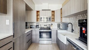 A modern kitchen with built-in appliances, a coffee maker, and a water dispenser. - Charming, walk-to-lifts condo with hot tubs, pool, gym & gas fireplace (Breckenridge)