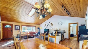 A spacious living area with a wooden dining table, a kitchen with modern appliances, and a cozy seating area. - Wonderful Getaway Near Town & Slopes W/ Fast WiFi, Full Kitchen, Deck & More (Breckenridge)