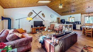 A spacious living area with a large sofa, a smaller sofa, a coffee table, and a TV. There is a kitchen in the background with a dining table and chairs. - Wonderful Getaway Near Town & Slopes W/ Fast WiFi, Full Kitchen, Deck & More (Breckenridge)