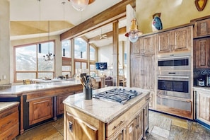 A spacious kitchen with a large island, wooden cabinets, and a view of the mountains. - Luxury alpine home in heart of Breckenridge - fireplace, hot tub, pool table (Breckenridge)