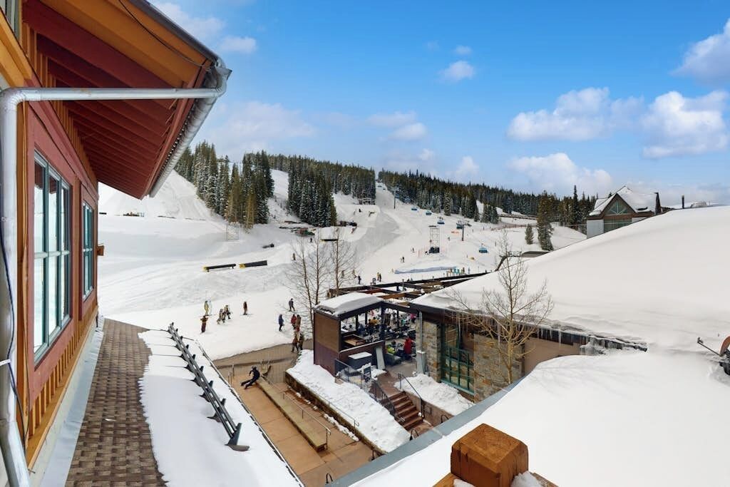 Ein Skigebiet mit einem Gebäude, einem überdachten Außenbereich und verschneiter Landschaft.