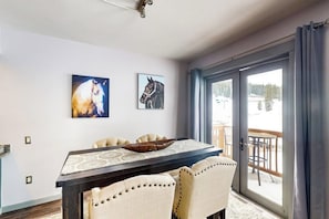 A dining area with a table, chairs, and two horse-themed wall art pieces. - Ski-in/out condo in Center Village with hot tub, sauna, gym & fireplace (Copper Mountain)