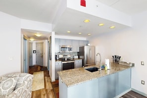 A modern kitchen with granite countertops, stainless steel appliances, and a central island. - Ski-in/out condo in Center Village with hot tub, sauna, gym & fireplace (Copper Mountain)