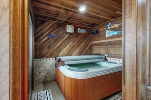 A wooden interior with a hot tub, wooden walls, and a tiled floor. - Cozy condo w/ a private hot tub & Fraser Valley views (Fraser)