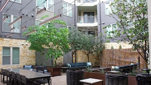 An outdoor patio with a dining table, chairs, and seating areas. - King Bed + Queen Bed - In the Heart of Addison’s Social Scene (Addison)