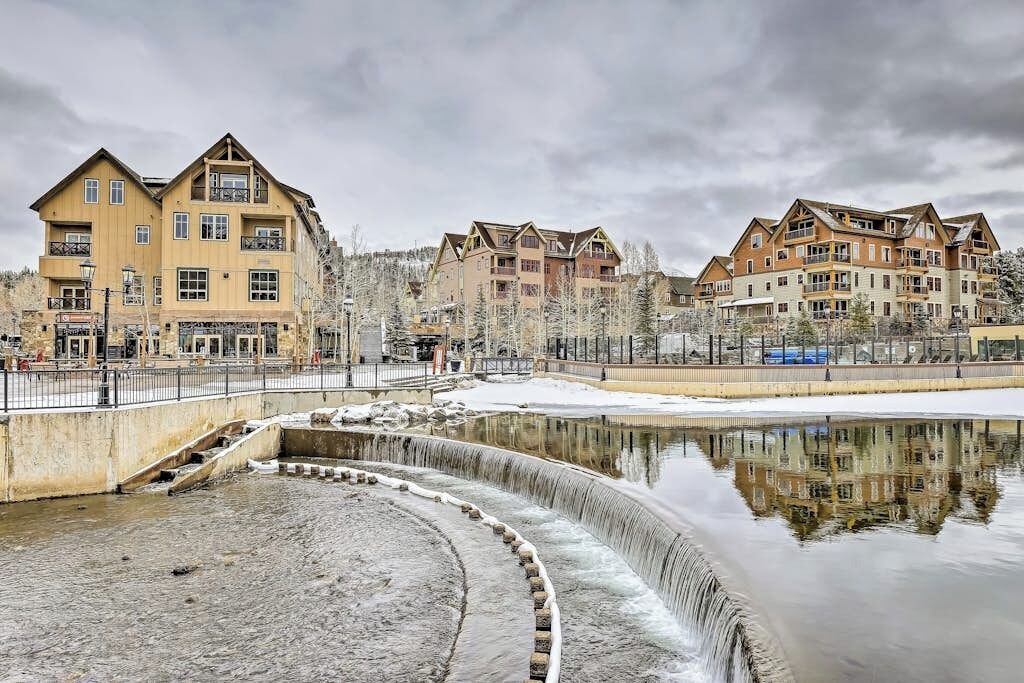 Ein Hotel mit mehreren Etagen, Balkonen und einem Spiegelbild in einem Wasserspiel.