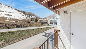 A balcony with a view of a snow-covered landscape and a road. - Charming Condo with Indoor Pool and Hot Tub - On Bus Line Half-Mile to Slopes (Crested Butte)