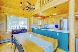 A wooden cabin interior with a dining area, kitchen, and large windows. - Spacious dog-friendly cabin with fireplace, mountain view, washer/dryer, & WiFi (Fairplay)