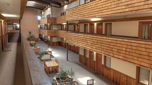 A multi-level hotel interior with wooden paneling, multiple balconies, and seating areas. - 2nd-floor mountain-view condo with sauna, balcony, kitchen - walk to lifts (Crested Butte)