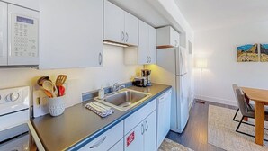 A modern kitchen with white cabinets, a built-in oven, a coffee machine, and a sink. - Mountain-view condo with balcony - walk to ski lifts, near downtown Crested Butte (Crested Butte)