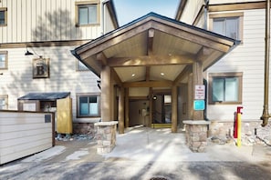 A building entrance with a covered porch, stone pillars, and a sign indicating no parking. - Ski condo with fireplace, washer/dryer, hot tubs - close to lifts & Main Street (Breckenridge)