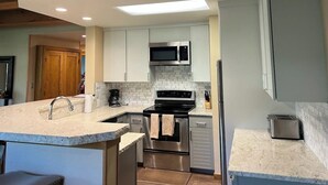 A modern kitchen with white cabinets, a stainless steel microwave, and a built-in oven. - Rustic retreat with slopeside access, mountain views & cozy fireplace (Crested Butte)