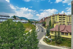 A multi-story building with a flat roof, surrounded by greenery and a road with vehicles. - Rustic retreat with slopeside access, mountain views & cozy fireplace (Crested Butte)