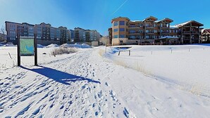 A snow-covered landscape with a ski resort building featuring multiple floors and balconies. - Premier Lake Dillon Condominium, 20 Min Access To 5 Resort Towns (Frisco)