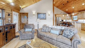 A log cabin interior with a living room, kitchen, and dining area. - Secluded home with amazing mountain & lake views, deck, fireplace, & WiFi (Durango)