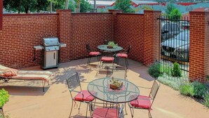 A patio with a grill, seating, and a view of a mountain.