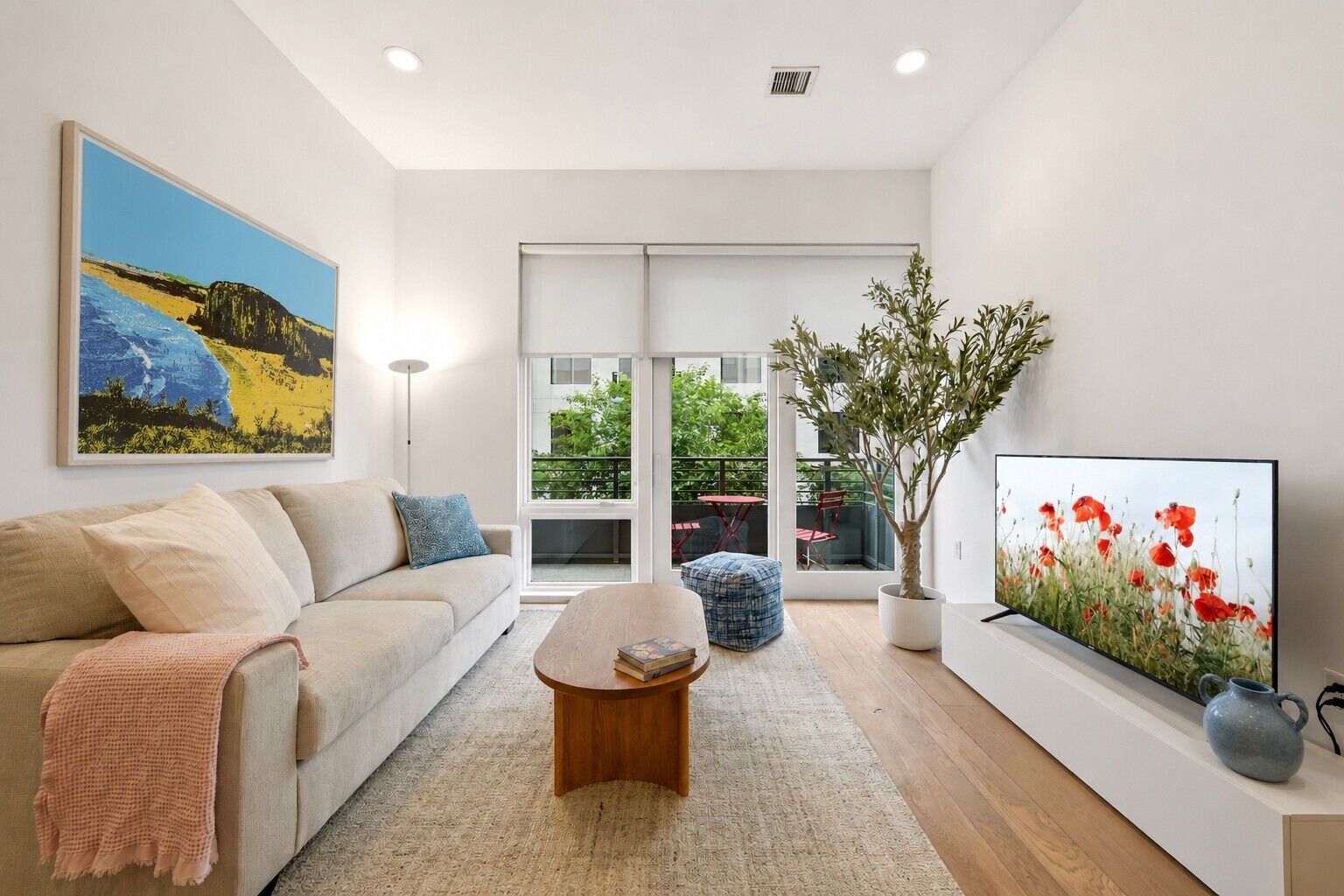 A modern living room with a sofa, coffee table, and artwork.