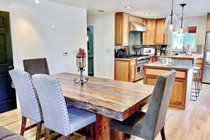 A modern kitchen with wooden cabinets, a central island, and a dining area with a wooden table and upholstered chairs. - Mountain-view home in great location with walk-out apt, 2 kitchens, & W/D (Durango)
