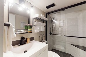 Ein modernes Badezimmer mit Waschbecken, Spiegel und Handtuchhalter.