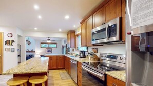 A modern kitchen with wooden cabinets, stainless steel appliances, and a granite countertop. - Dog-friendly townhome with mountain view, fireplace, patio, grill & W/D (Durango)