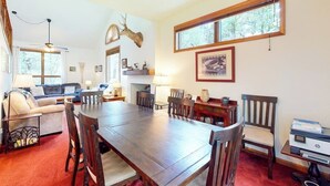 A dining room with a large wooden table, chairs, a fireplace, and a deer head mounted on the wall. - Dog-friendly townhome with mountain view, fireplace, patio, grill & W/D (Durango)