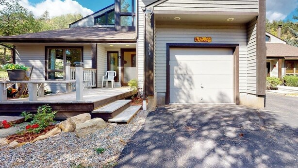 A two-story house with a covered porch, a garage, and a driveway. - Dog-friendly townhome with mountain view, fireplace, patio, grill & W/D (Durango)