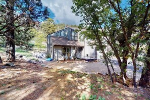 Ein modernes, zweistöckiges Haus mit geneigtem Dach, großen Fenstern und einer Veranda.