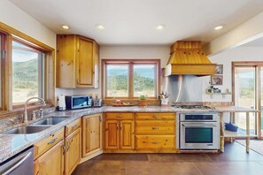 A kitchen with wooden cabinets, a microwave, a stove, and a sink.