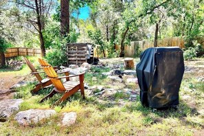 A rustic outdoor seating area with a wooden chair and a covered grill. - Upper apartment with deluxe kitchen, private W/D, & great location (Durango)