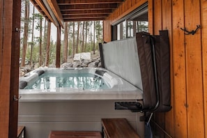 A hot tub in a wooden cabin with a view of a forest. - Riverfront Hot Tub Mountain Retreat (Grand Lake)