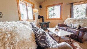 Ein gemütliches Wohnzimmer mit Kamin, Ledersofas und einem flauschigen Teppich.