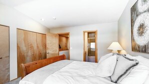 Une chambre à coucher avec un lit, une armoire en bois et un tableau accroché au mur.