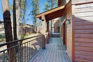 Eine Holzhütte mit einer Terrasse, umgeben von Bäumen.