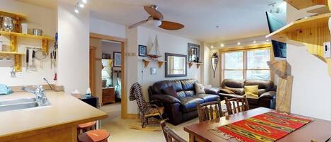 Un espacio habitable compacto con cocina, comedor y zona de estar.