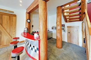 A bar area with stools, a counter, and wooden beams. - Well-appointed home with home theater, radiant heat & private hot tub (Fraser)