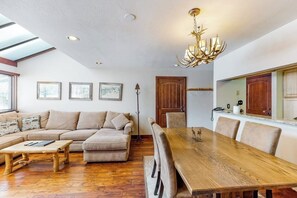 Ein Wohnzimmer mit einer Couch, einem Esstisch und einer Chandelier.