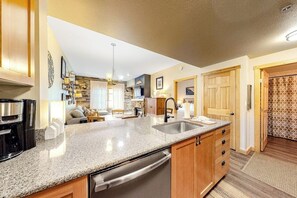 A kitchen with granite countertops, stainless steel appliances, wooden cabinets, and a built-in dishwasher. - Spacious & Bright Condo W/ Shared Pool, Easy Ski Access & Free WiFi (Copper Mountain)