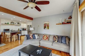 A modern living room with a sofa, coffee table, and a ceiling fan. - Ground-Floor Condo with WiFi, Laundry & Prime Location - Walk Everywhere (Frisco)
