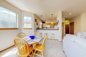 Un espai habitable compacte amb zona de menjador, petita cuina i sofà.