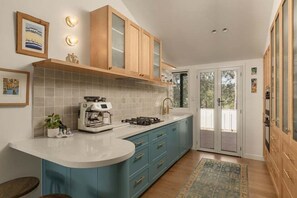 Eine Küche mit weißer Arbeitsplatte, blauen Schränken, einem Gasherd und einem Backofen.