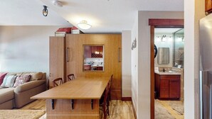 En kompakt bolig med spiseplads, tekøkken og sofa.