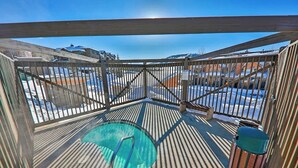 Uma área externa coberta com mesa de bilhar, lixeira e vista para uma paisagem nevada.