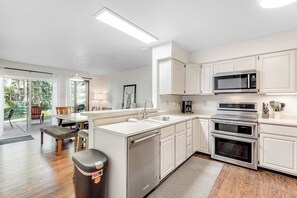 A modern kitchen with white cabinets, a built-in microwave, and a double oven. - Dog & Family-Friendly Home with Firepit, Deck, Fireplace, W/D, & Free WiFi (Frisco)