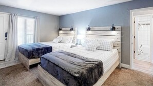 Een slaapkamer met twee bedden, een raam met gordijnen, een deur en een witte muur.